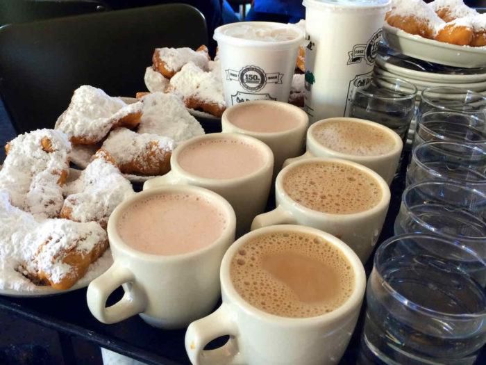 tray of beignets and cafe au lait in cafe du monde new orleans