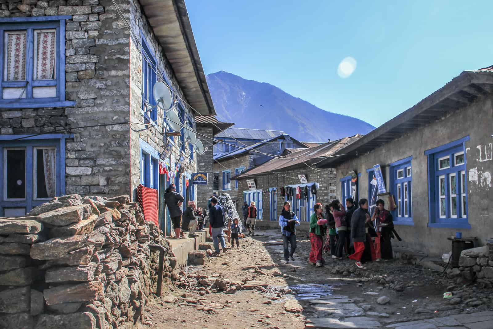 The sandy toned streets and houses with blue window frames in the Nepal town of Lukla in the Himalaya moumntains