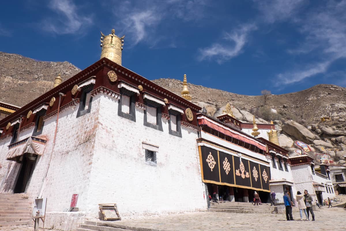 The white exterior building with red and golden rooftops of the Sera Monastery in Lhasa Tibet