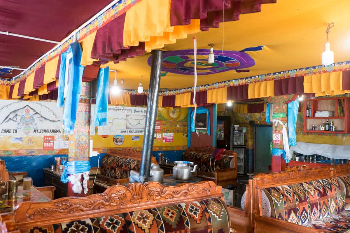 The colourful yellow and red material interior design of the lounge area of Rombuk Monastary in Tibet Everest Base Camp