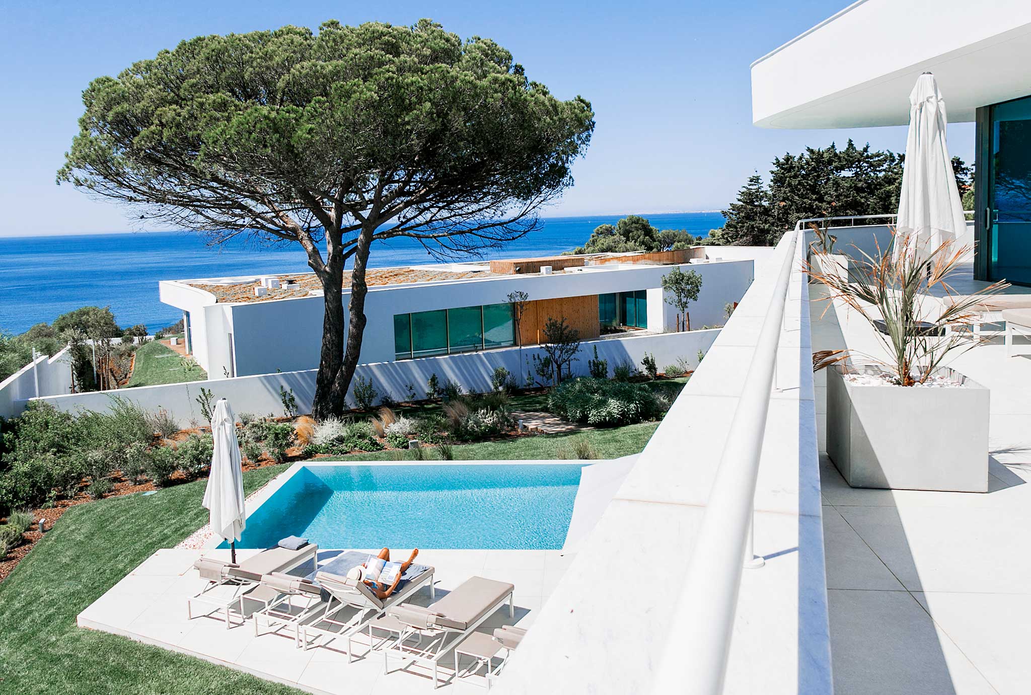 Looking out on the Atlantic ocean and an infnity pool with two white luxury villas in the picture at Lux Mare