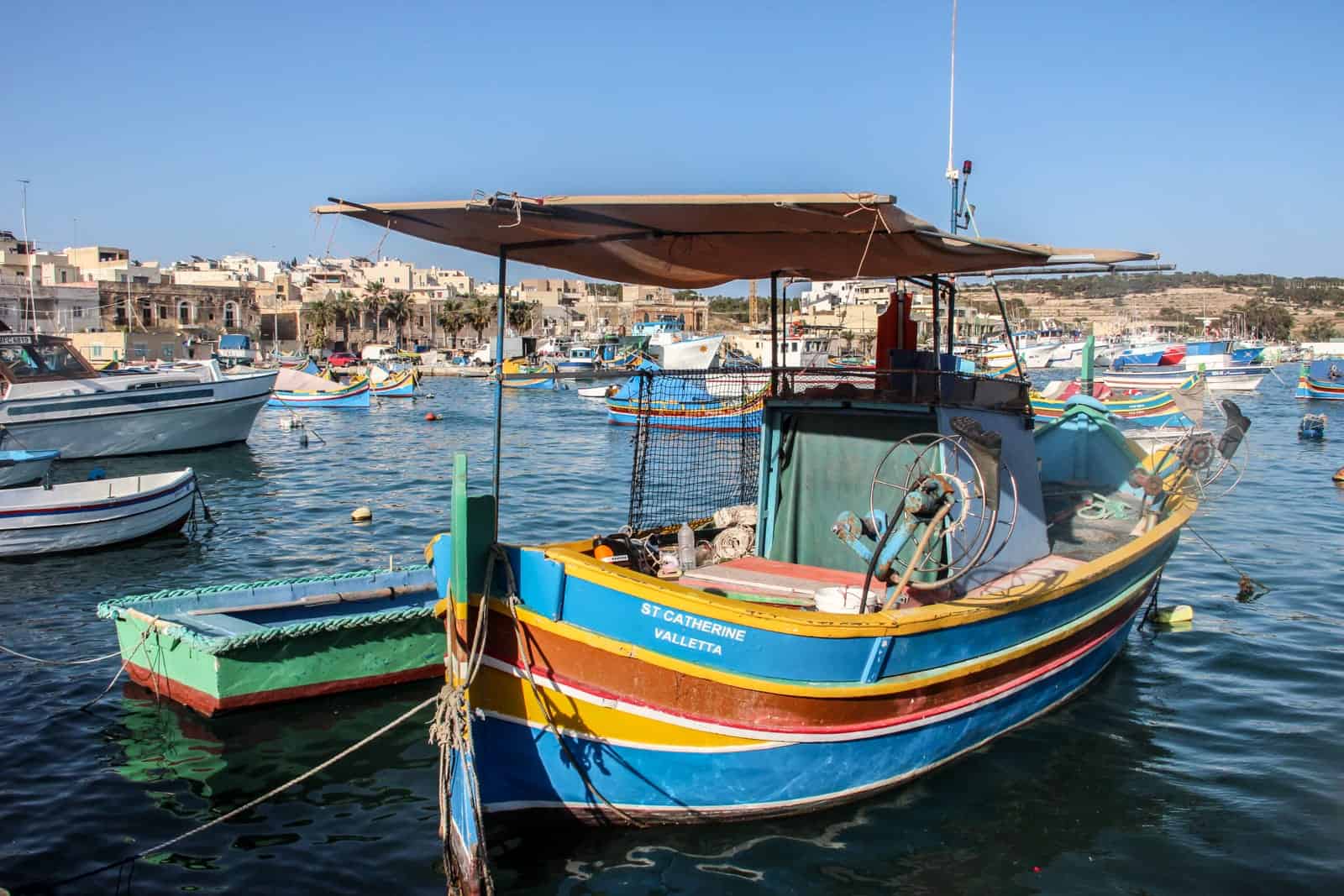 Colourful boats line the water at the pretty fishing village of Marsaxlokk in Malta