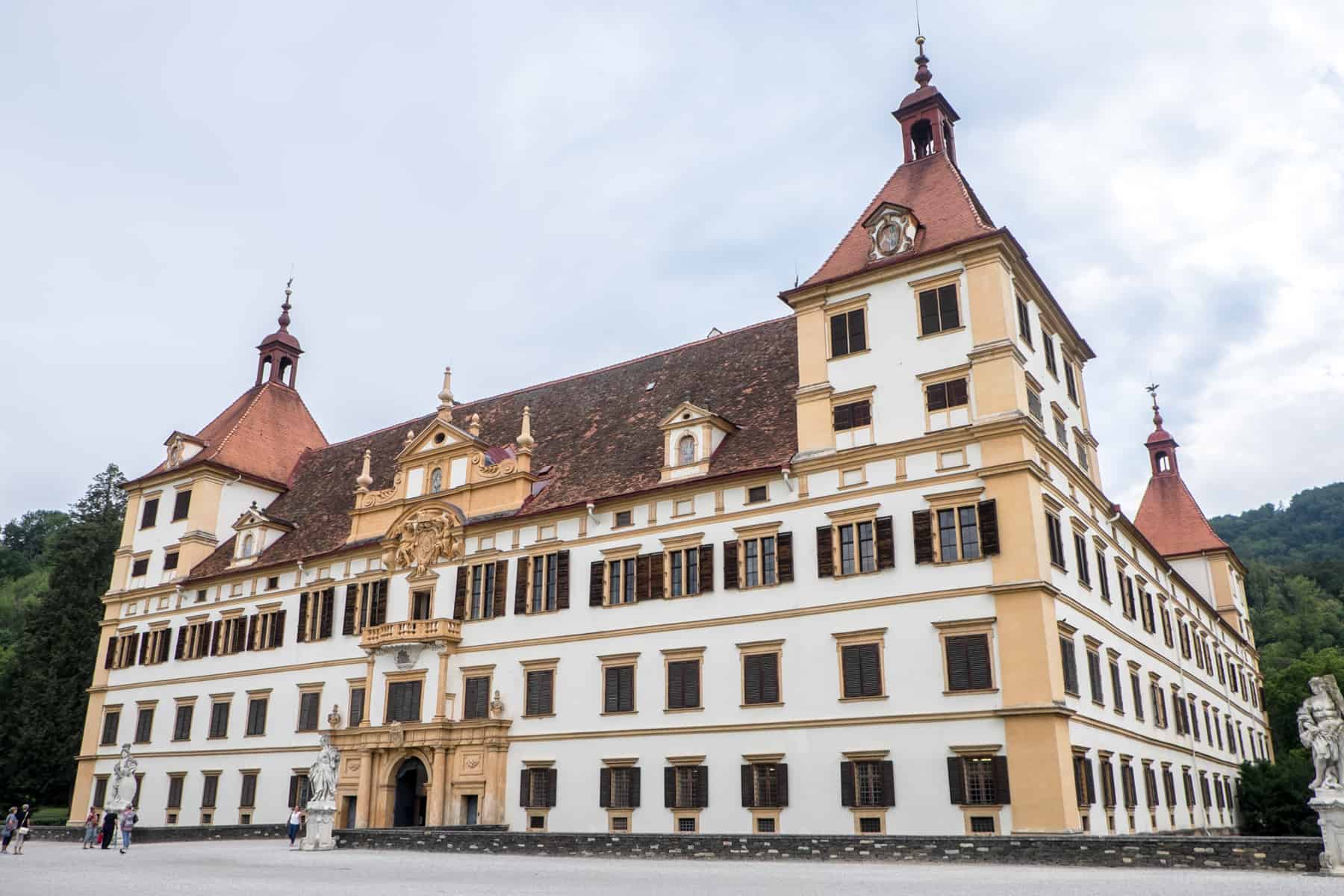 The four towers, white and yellow building with a deep red roof of Schloss Eggenberg Palace in Graz, Austria
