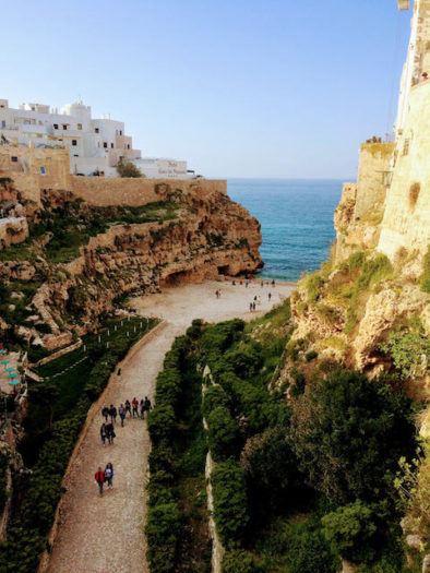 walk to the beach with towering cliffs in polignano a mare puglia italy