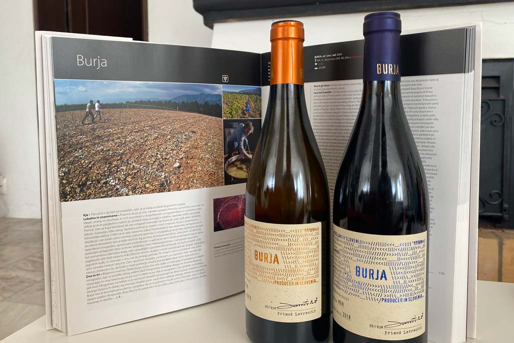 Two bottles of Burja wine in front of their description in a heavy coffee table book