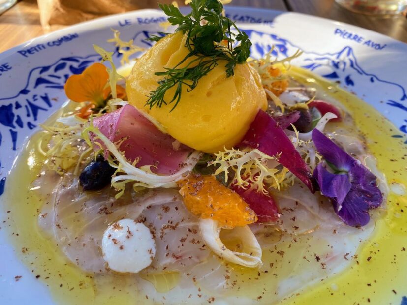 beautiful plate of fish carpaccio with decorative flowers and mousse