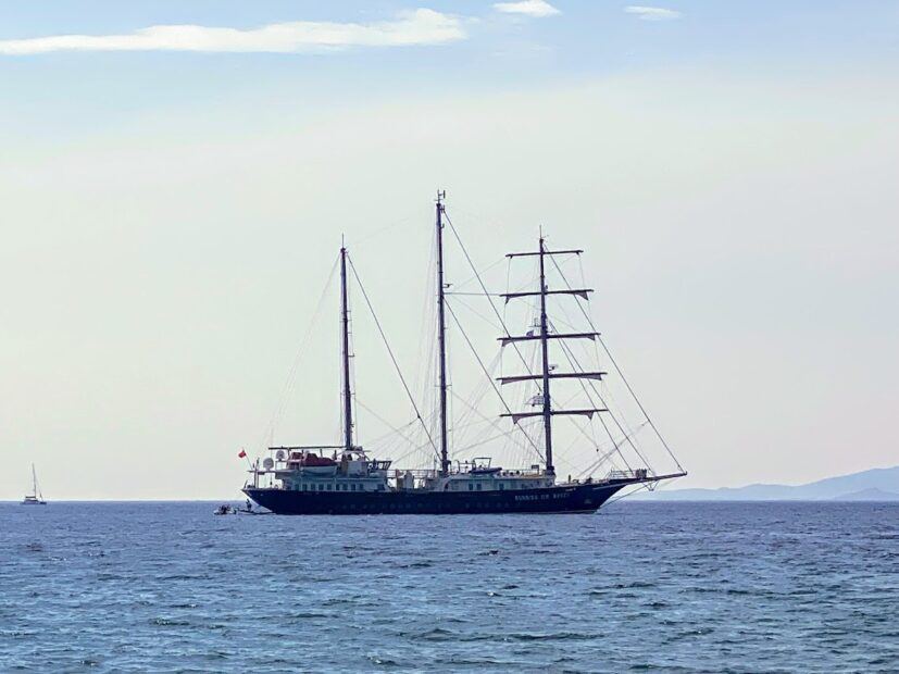 Distance view of luxury yacht running on waves in the Greek Islands