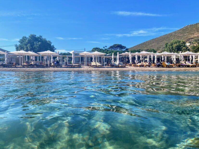 Quiet beach on Patmos island with sun loungers. View from the sea to shore.