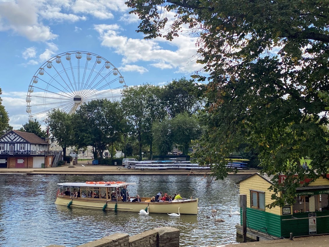 Canal boat at the Waterside in Stratford-upon-Avon with swans and observation wheel