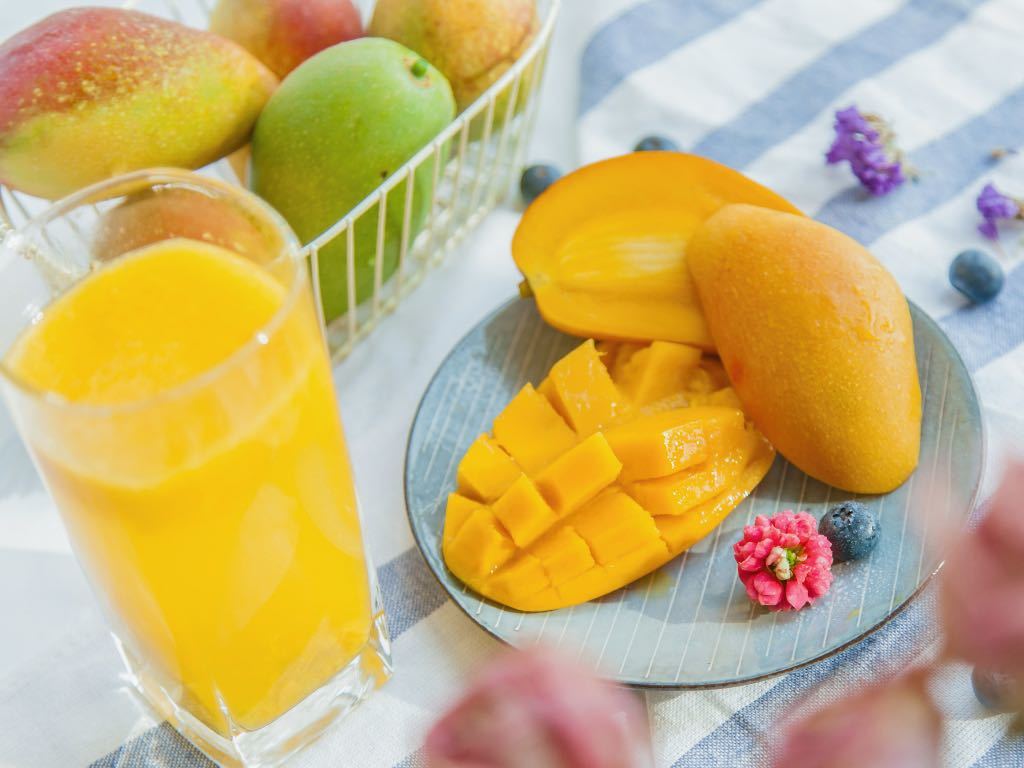 mango chopped on a plate with flower and juice