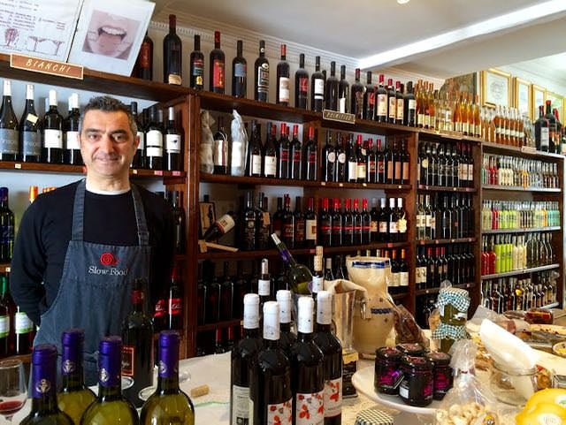 Wine seller in wine shop with Primitivo bottles