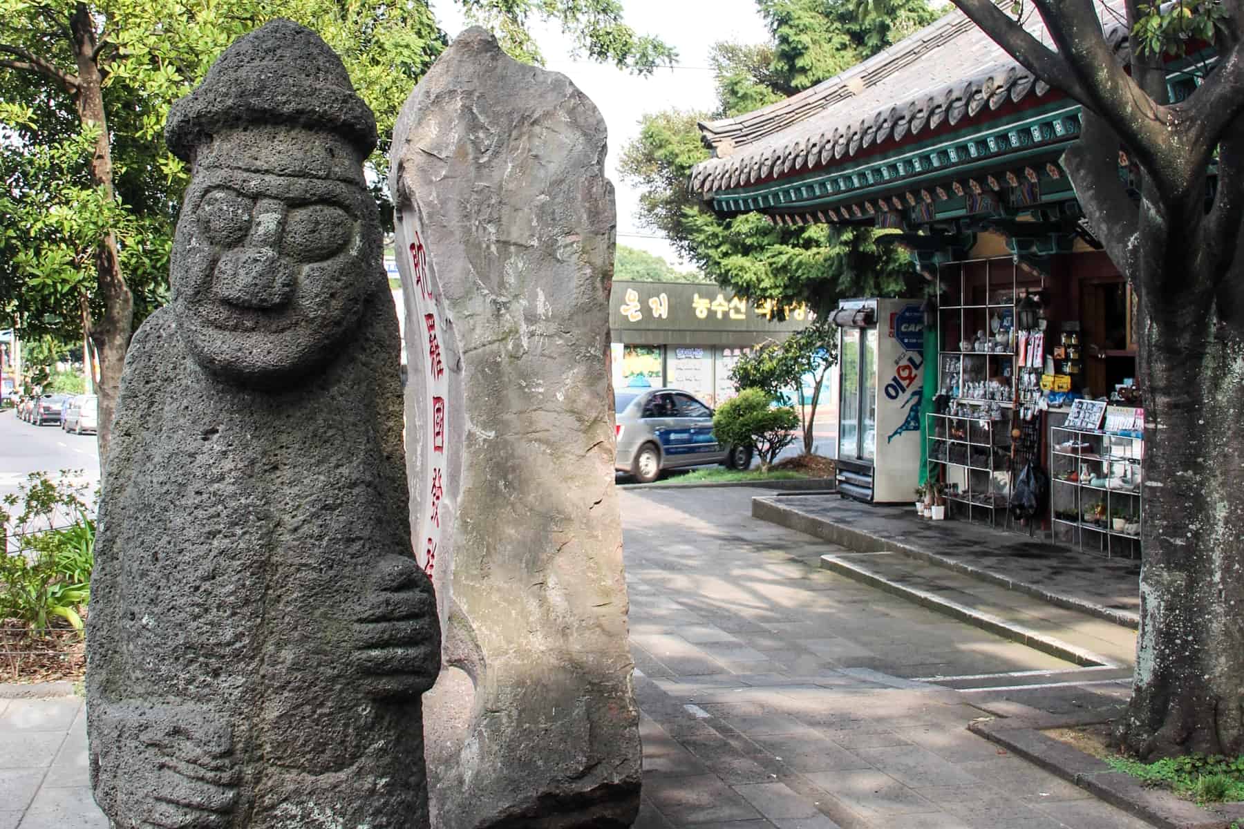 The male looking, bulging eyed Jeju Island Dol hareubang Stone Statues. This one stands outside a store, and is said to offer protection.