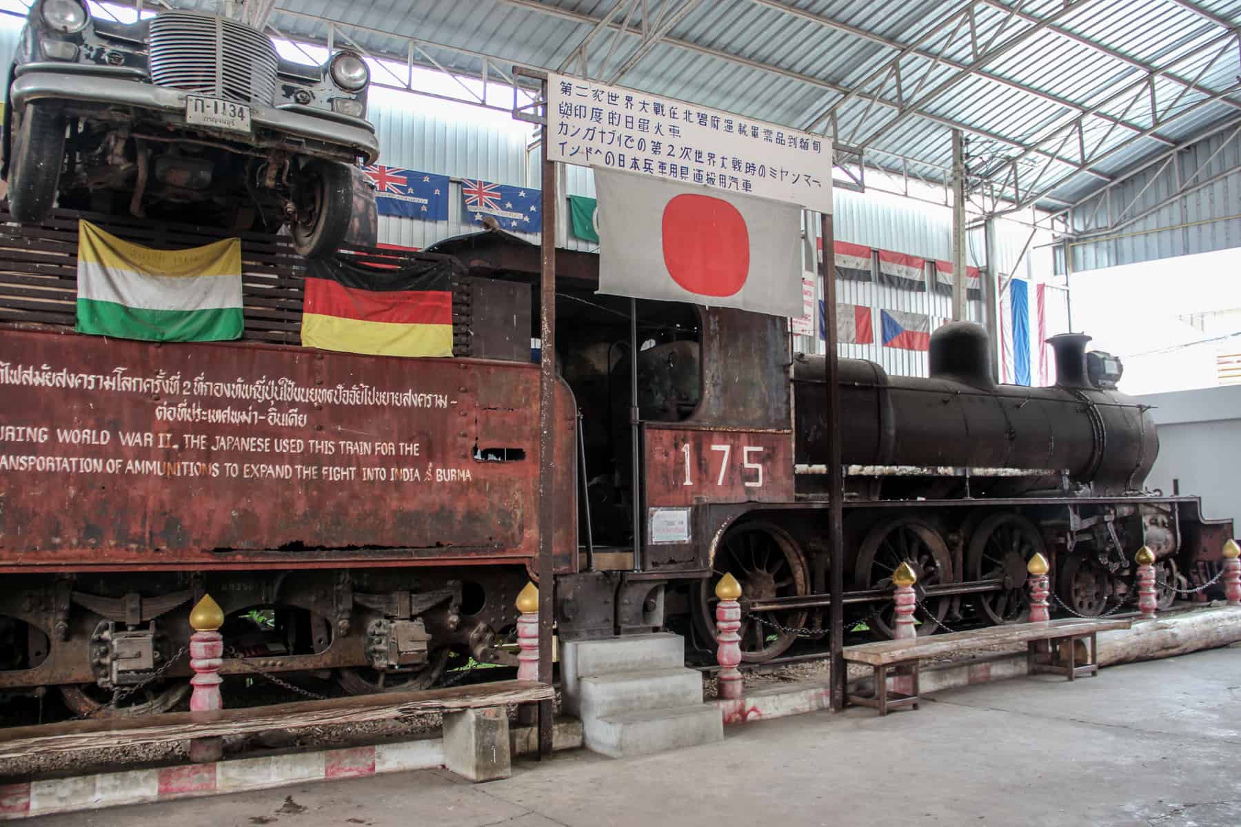 A red and black rusty Japanese train used during WWII on display at the JEATH Museum in Thailand.