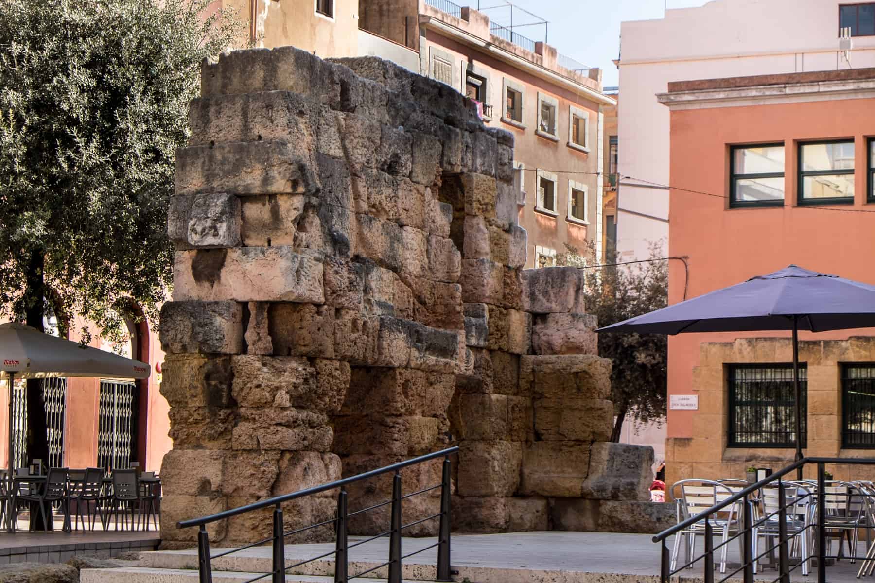 Remains of Roman Ruins in the streets of Tarragona, in a public square right outside of pastel coloured apartment buildings