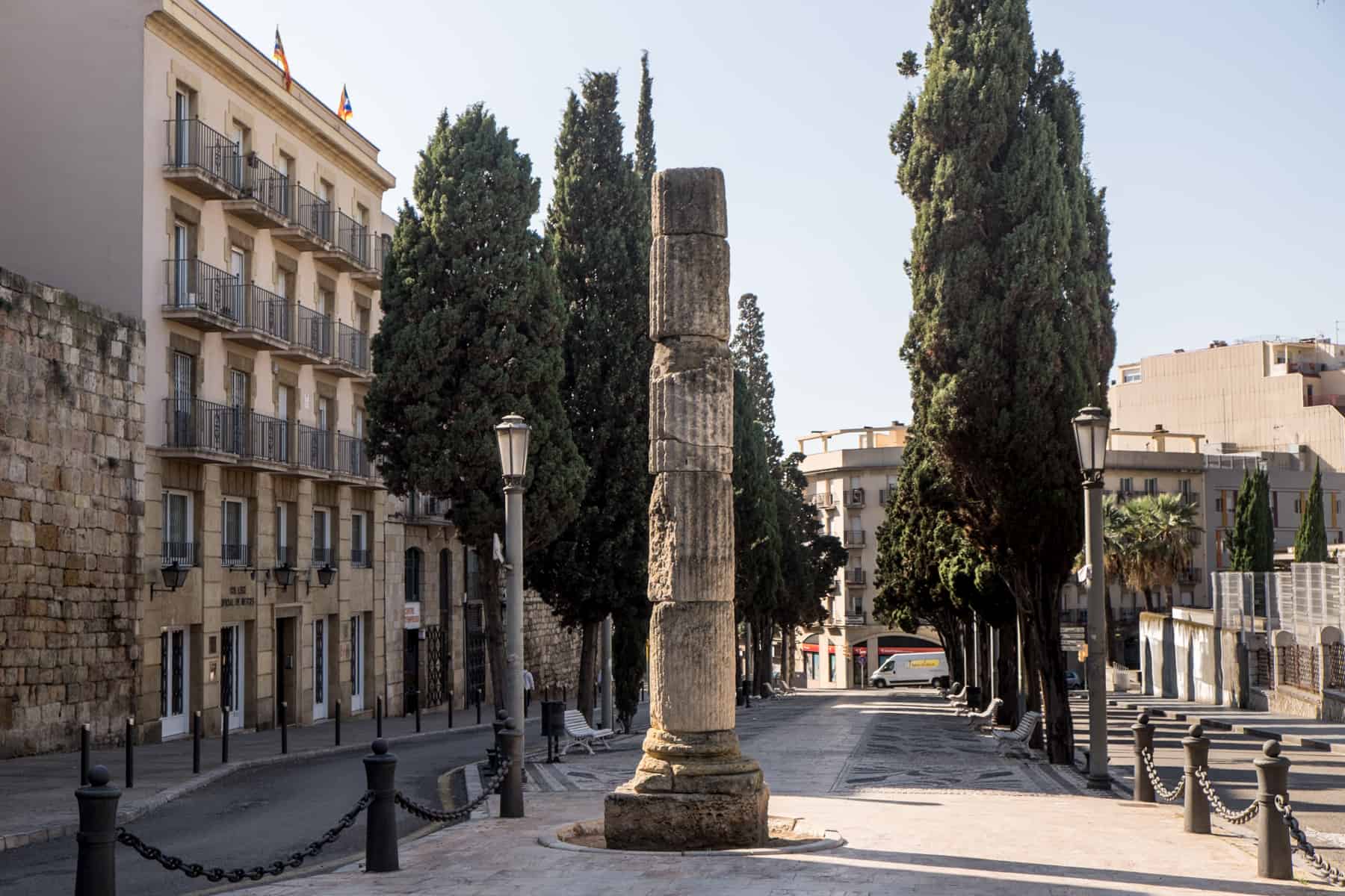 A stone Roman Column in the middle of a pedestrian street in Tarragona Spain