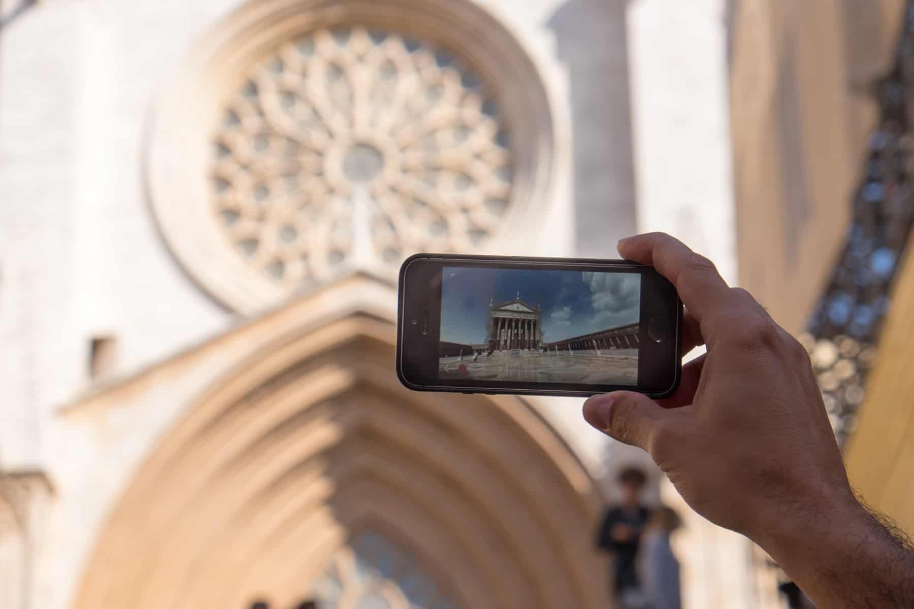 A hand holding up a smart phone displaying the roman ruins virtual reality app for Tarragona Tourism