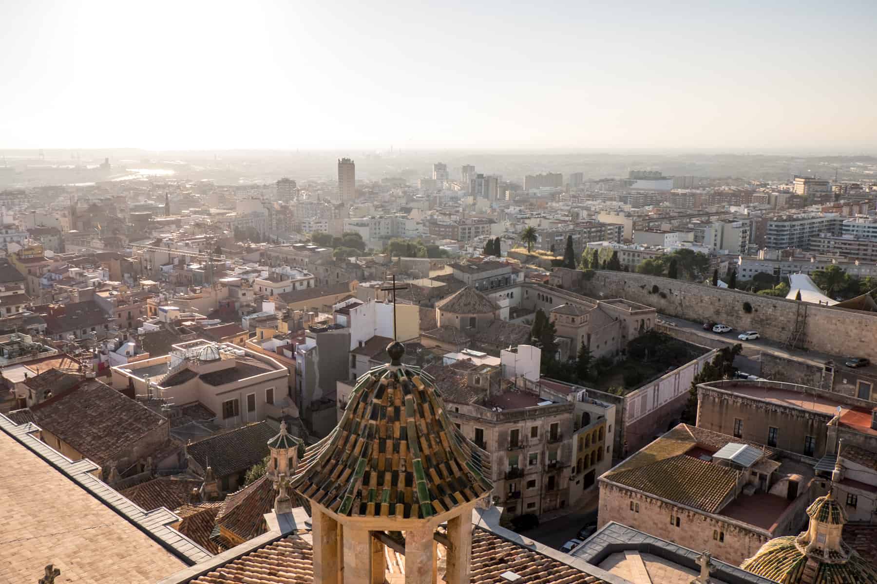 An arial view of the golden structures, dombs and roofs of Tarragona, Spain, in a golden glow from afternoon sun
