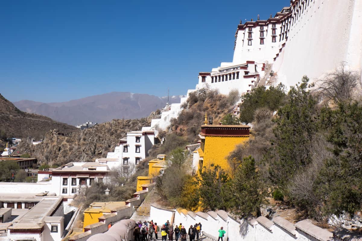 Tourists climbing up the hundreds of steps of the elevated Potala Palace in Lhasa, Tibet to reach the entrance and begin a tour