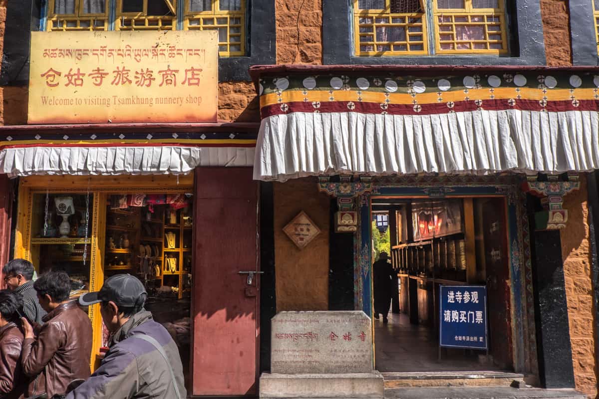 Traditional Tibetan exterior of the Ani Tsankhung Nunnery shop in Lhasa where white material with black, orange and red trim hangs over each doorway