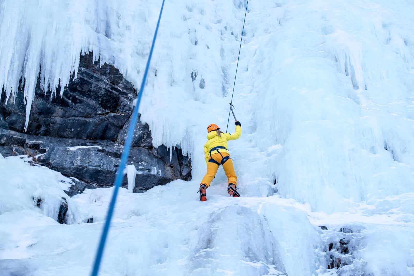 Woman ice climbing one of Banff's frozen waterfalls