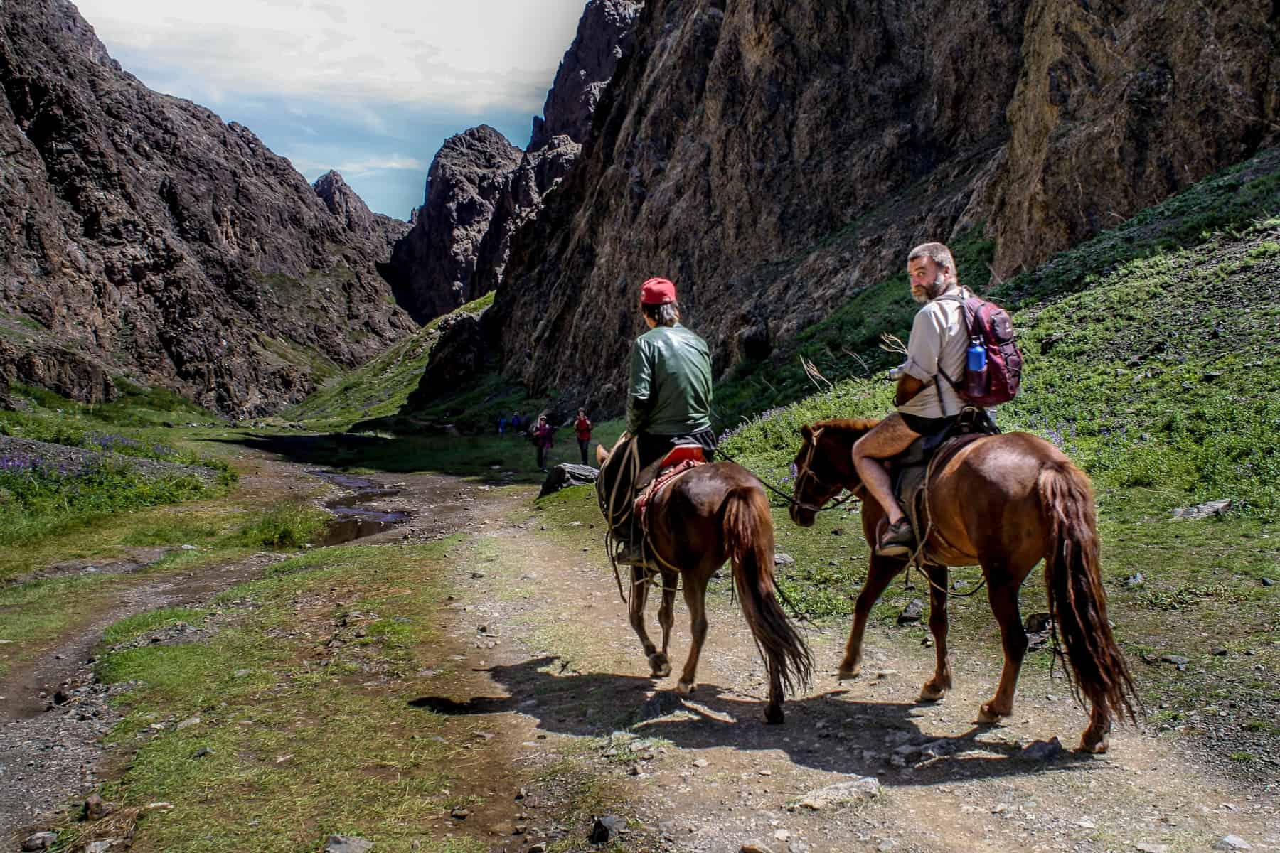 Two men travel by horseback in the Yolin Am valley in Mongolia