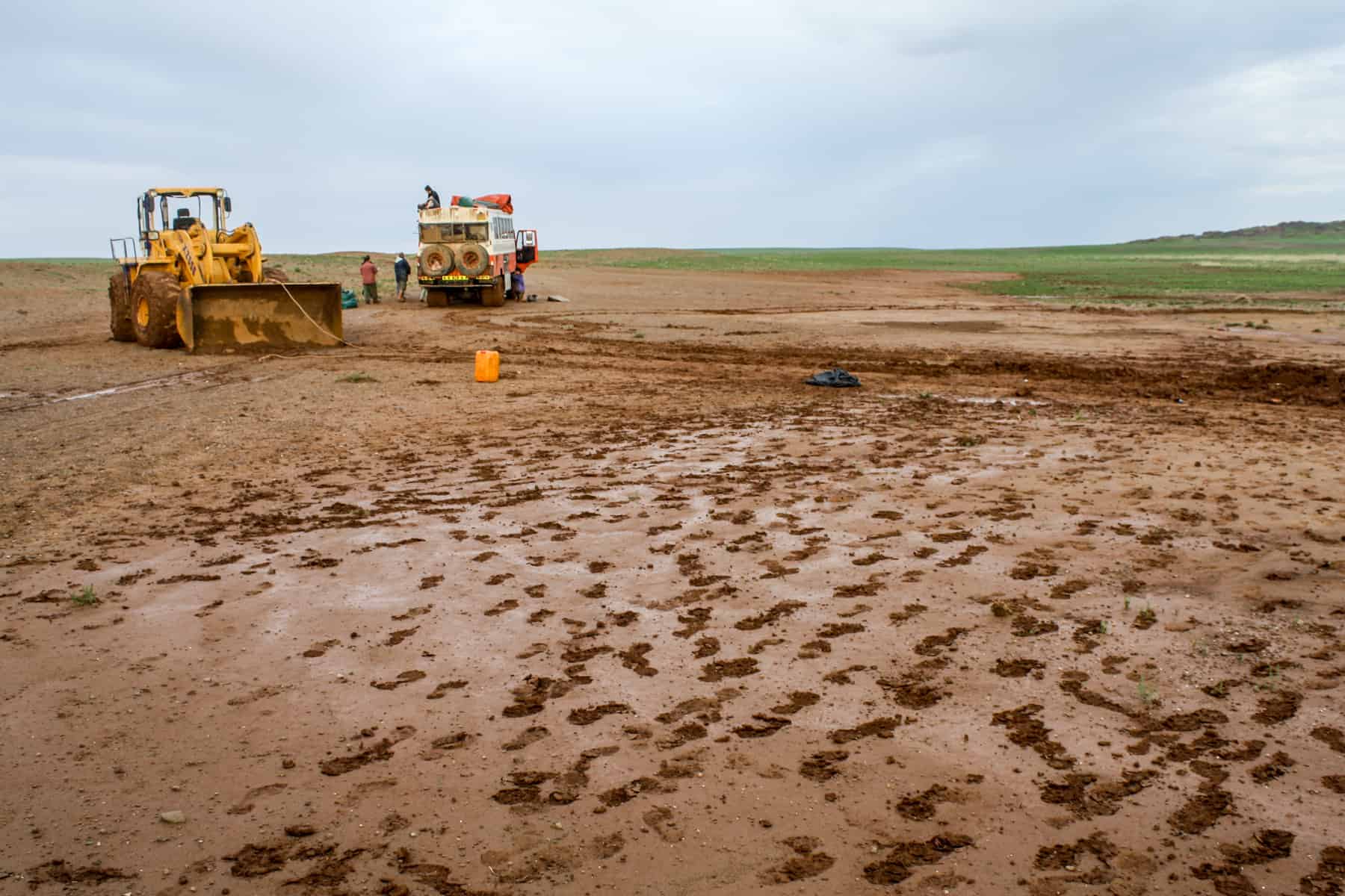 Tractors help pull the overlanding truck out of the sticky mud in Mongolia's rural landscape