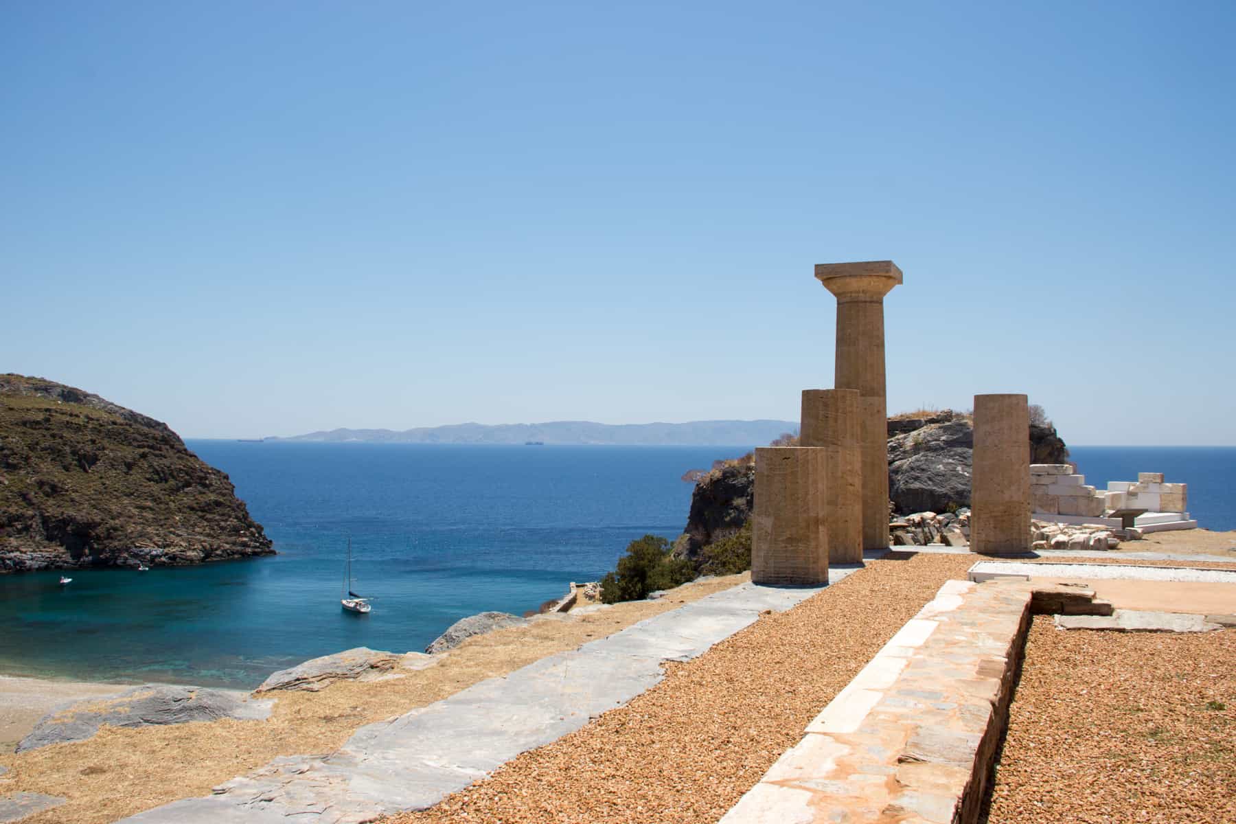 The four columns of the Temple of Athena sit on a hillside of the ancient city of Karthea in Kea island, overlooking the shimmering blue ocean water