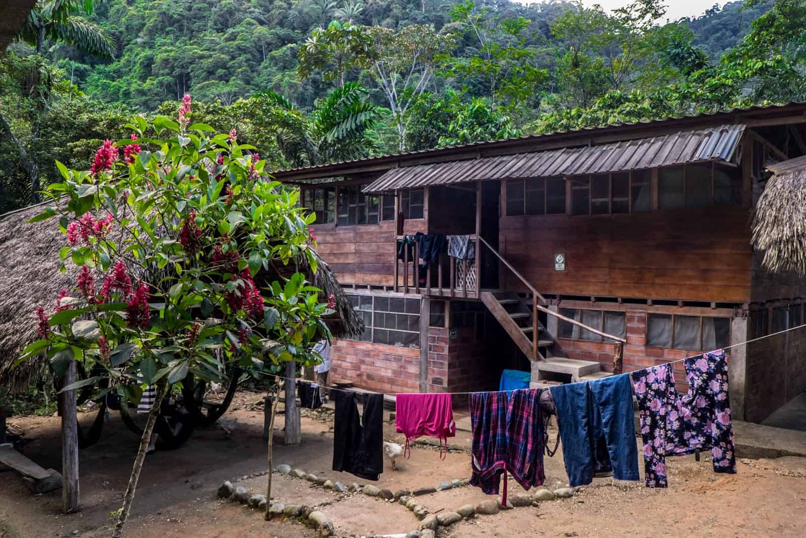 A line of washing in front of a large wooden two-story lodge, surrounded by the Ecuador Amazon jungle. 