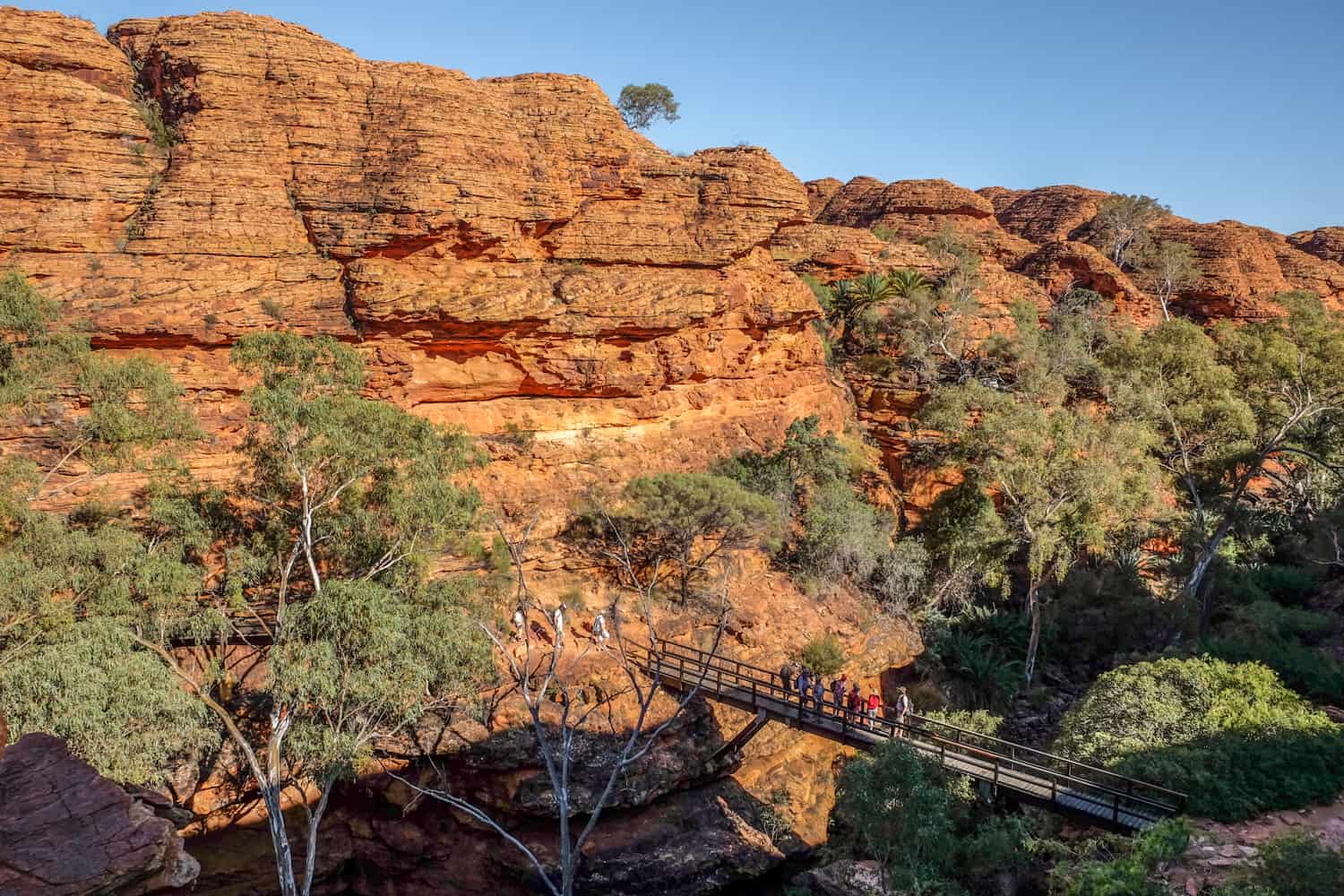 People on a walkway inside the deep King's Canyon near Alive Springs, Australia. 