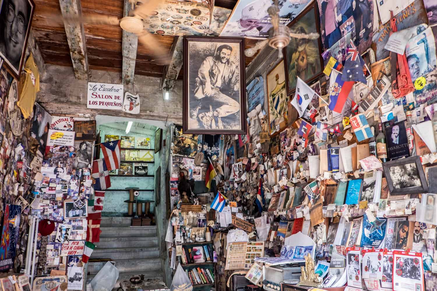 A bookstore in Cuba floor to ceiling with books, posters and framed images. 
